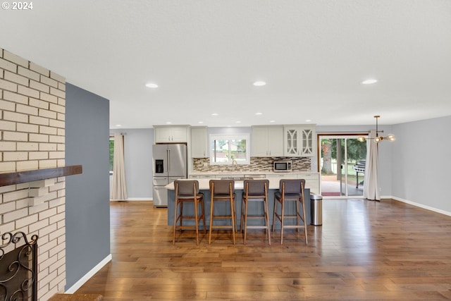 kitchen with white cabinets, dark hardwood / wood-style floors, a healthy amount of sunlight, and appliances with stainless steel finishes