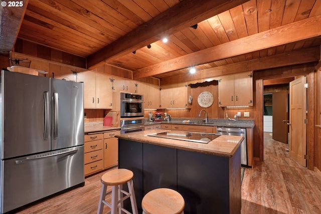 kitchen featuring a center island, sink, light hardwood / wood-style floors, beam ceiling, and stainless steel appliances