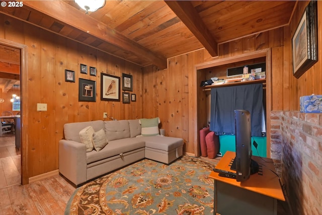 living room featuring beam ceiling, light hardwood / wood-style floors, wooden ceiling, and wood walls