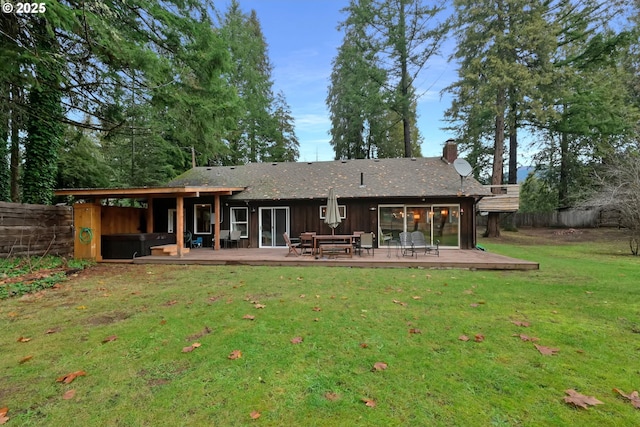 back of house featuring a wooden deck and a lawn