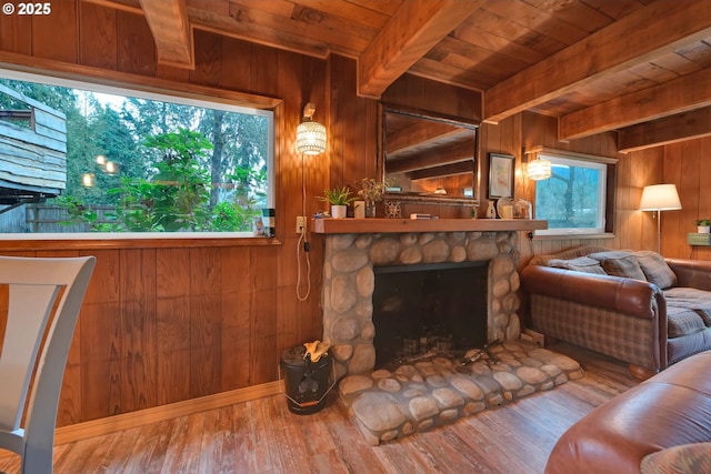 unfurnished living room with a stone fireplace, wood walls, and wood-type flooring