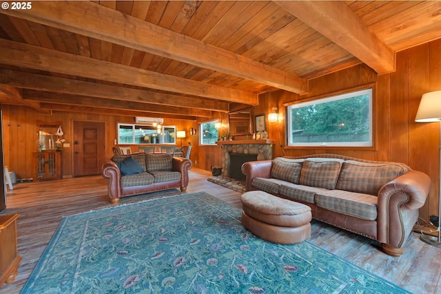 living room featuring wooden walls, hardwood / wood-style flooring, wooden ceiling, beamed ceiling, and a stone fireplace