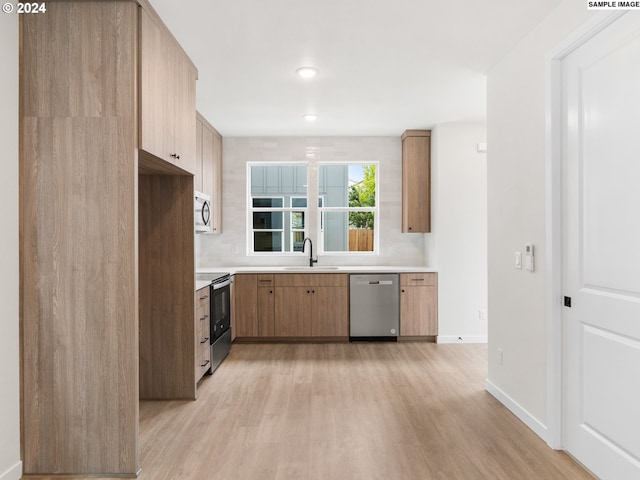 kitchen with sink, light hardwood / wood-style flooring, stainless steel appliances, decorative backsplash, and light brown cabinetry