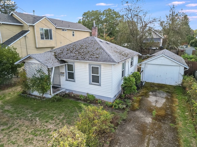 back of house with a lawn and an outbuilding