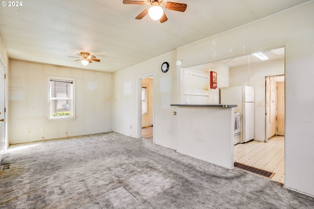 unfurnished living room with light carpet and ceiling fan