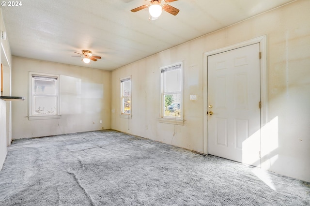 entryway with ceiling fan and light carpet