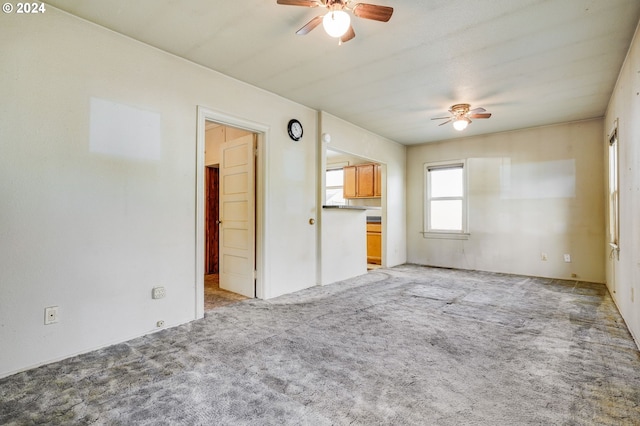 unfurnished living room with ceiling fan and light colored carpet