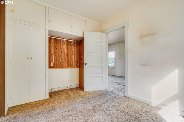 unfurnished bedroom featuring light carpet and a closet