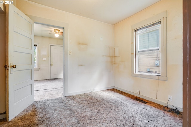 carpeted empty room with ceiling fan and a healthy amount of sunlight