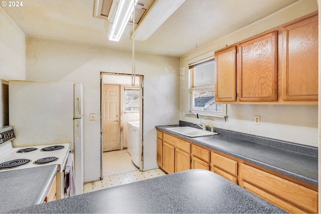 kitchen featuring washer / clothes dryer, white electric range oven, sink, and decorative light fixtures