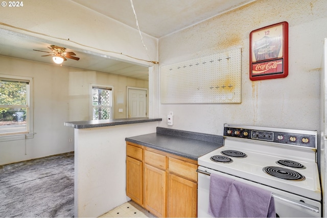 kitchen featuring light carpet, white range with electric cooktop, kitchen peninsula, and ceiling fan