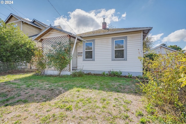 view of side of property with a lawn