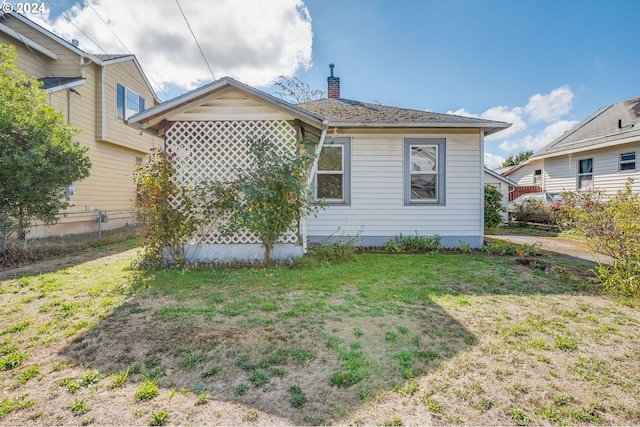 rear view of house featuring a yard