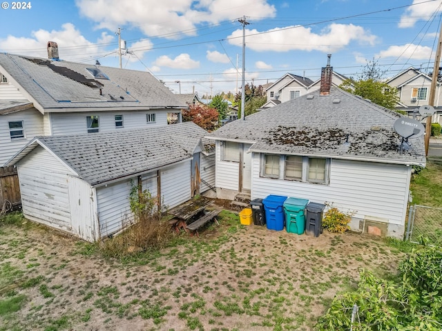 back of house featuring a storage shed