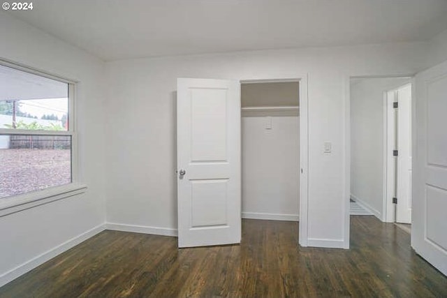 unfurnished bedroom featuring dark hardwood / wood-style floors and a closet