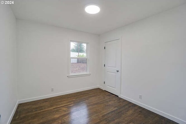 spare room featuring dark wood-type flooring