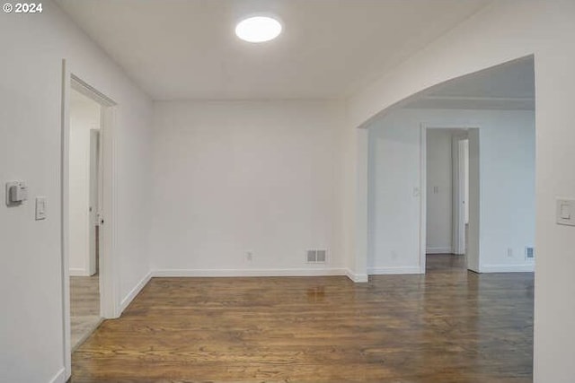 unfurnished room with dark hardwood / wood-style flooring