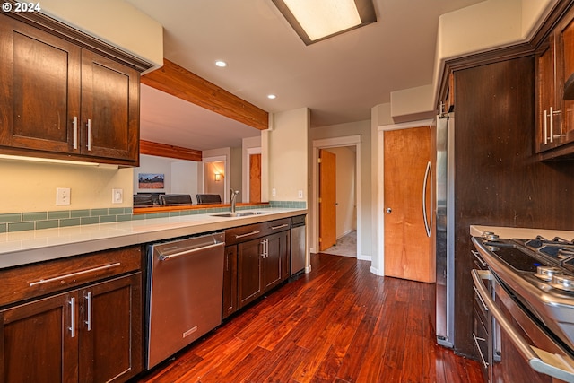 kitchen featuring dark brown cabinetry, stainless steel appliances, sink, and dark hardwood / wood-style flooring