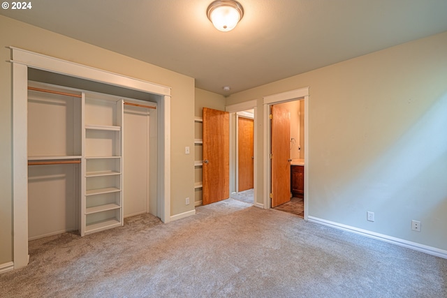 unfurnished bedroom with light carpet and a closet