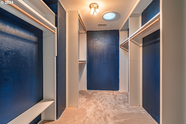 walk in closet featuring light carpet