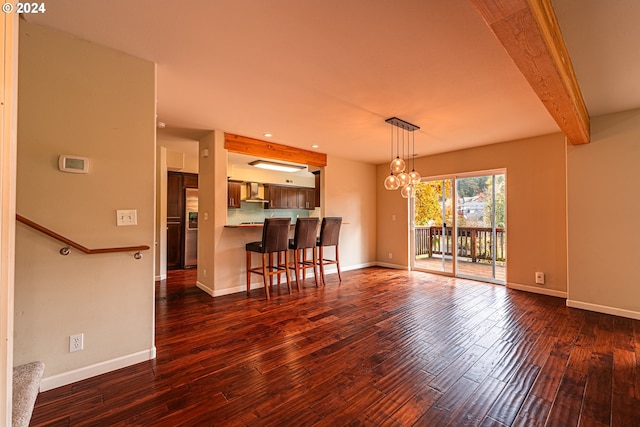 interior space featuring dark wood-type flooring, a chandelier, and beam ceiling