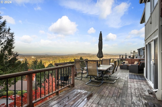 wooden deck featuring an outdoor hangout area, a mountain view, and outdoor dining area