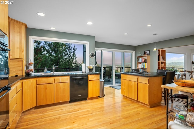 kitchen with a sink, light wood-type flooring, black appliances, and recessed lighting