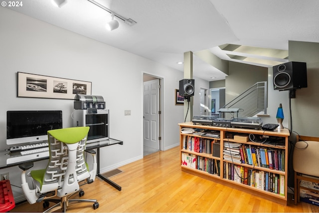 office featuring track lighting, wood finished floors, visible vents, and baseboards