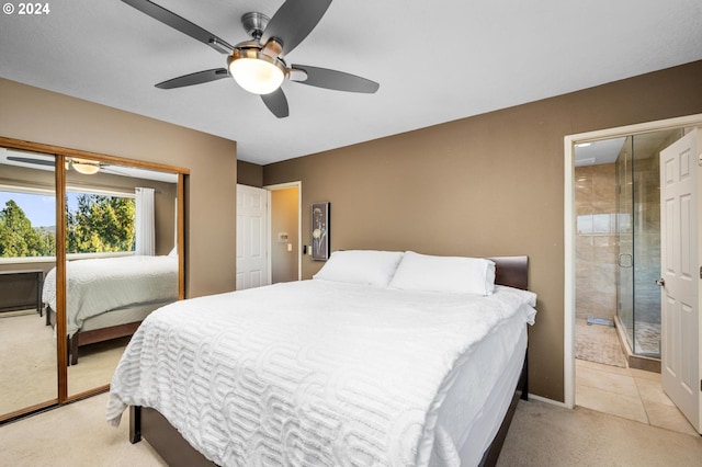 bedroom featuring light colored carpet, ensuite bath, and a ceiling fan