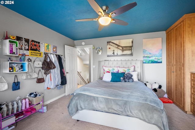 carpeted bedroom with baseboards, a textured ceiling, and a ceiling fan