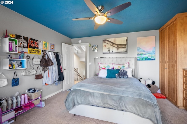 carpeted bedroom with baseboards and ceiling fan
