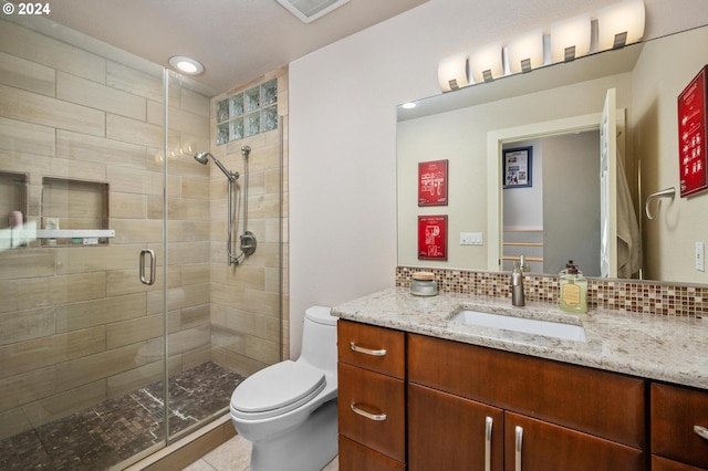bathroom with vanity, toilet, a shower stall, backsplash, and visible vents