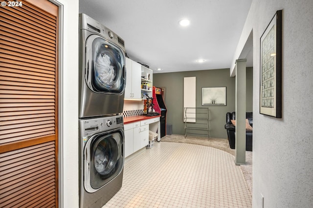 washroom featuring a textured wall, recessed lighting, carpet flooring, cabinet space, and stacked washer / drying machine