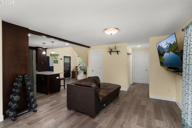 living area featuring stairs, wood finished floors, and baseboards