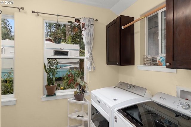 laundry room featuring washing machine and clothes dryer and cabinets