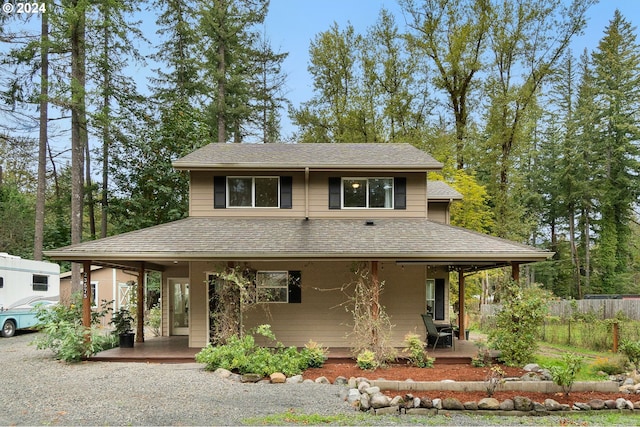 view of front of home featuring a patio, fence, and roof with shingles