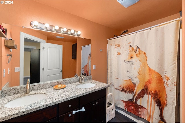 bathroom with double vanity, a shower with curtain, visible vents, and a sink