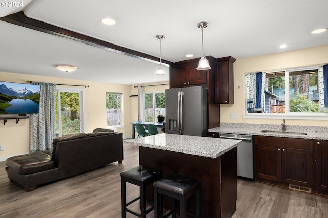 kitchen with visible vents, light wood-type flooring, a sink, stainless steel appliances, and open floor plan