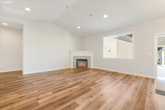 unfurnished living room featuring vaulted ceiling and light hardwood / wood-style floors