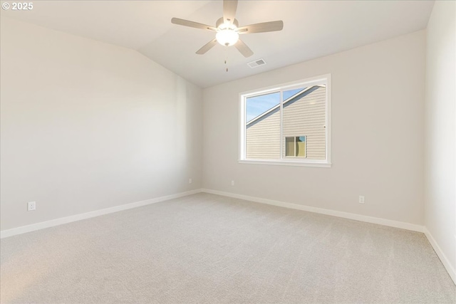 spare room featuring carpet floors, vaulted ceiling, and ceiling fan