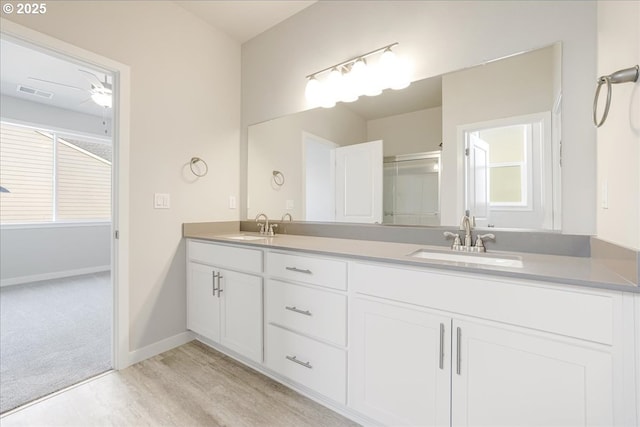 bathroom featuring vanity, ceiling fan, and walk in shower