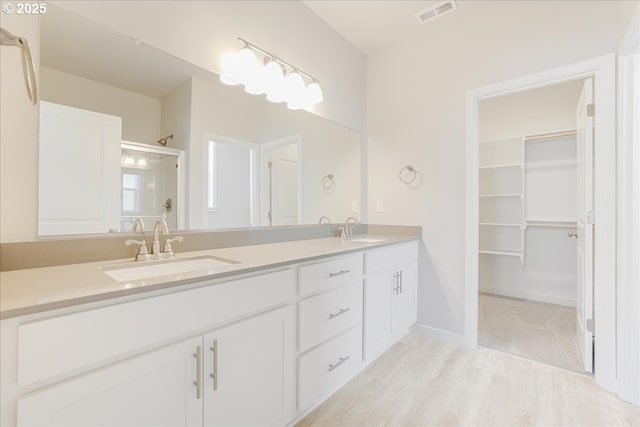 bathroom featuring vanity, wood-type flooring, and a shower with door