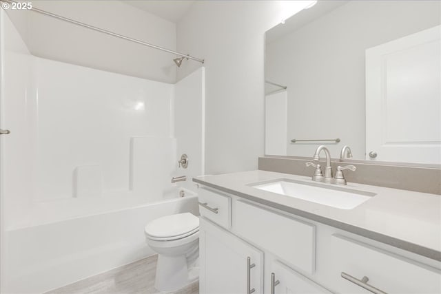 full bathroom with bathing tub / shower combination, hardwood / wood-style floors, vanity, and toilet