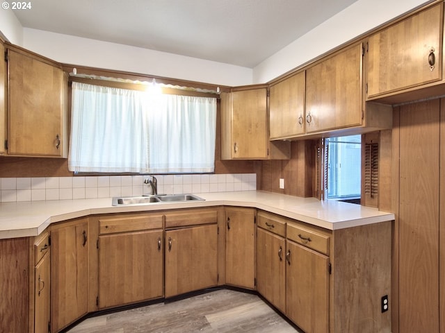 kitchen with decorative backsplash, sink, and light hardwood / wood-style floors