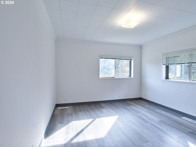 spare room with ornamental molding and hardwood / wood-style floors