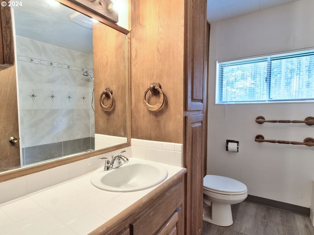 bathroom with walk in shower, wood-type flooring, vanity, and toilet