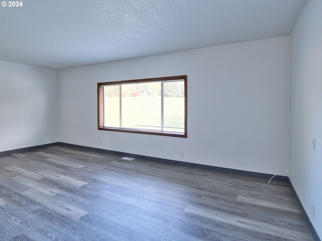 empty room featuring hardwood / wood-style floors and a textured ceiling