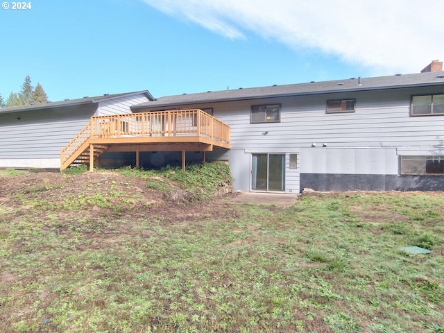 rear view of property featuring a deck and a lawn