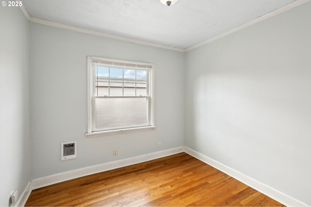 spare room with hardwood / wood-style flooring and crown molding