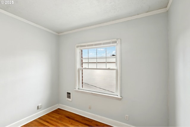 spare room featuring hardwood / wood-style floors and ornamental molding